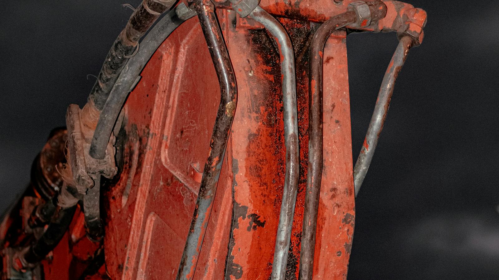 Vérins et flexibles hydrauliques sur le bras d'un engin de chantier