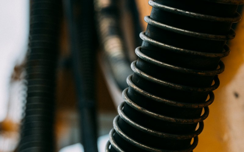 Gros plan d'un tuyau noir renforcé par une spirale métallique apparente